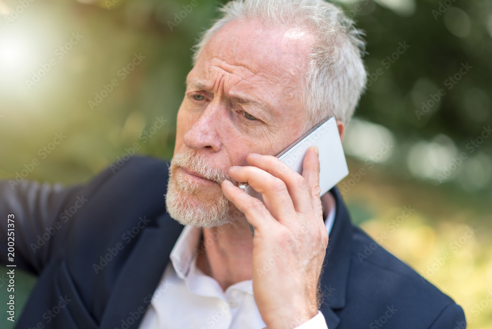 Mature man using his mobile phone, light effect Mature man using his mobile phone, light effect