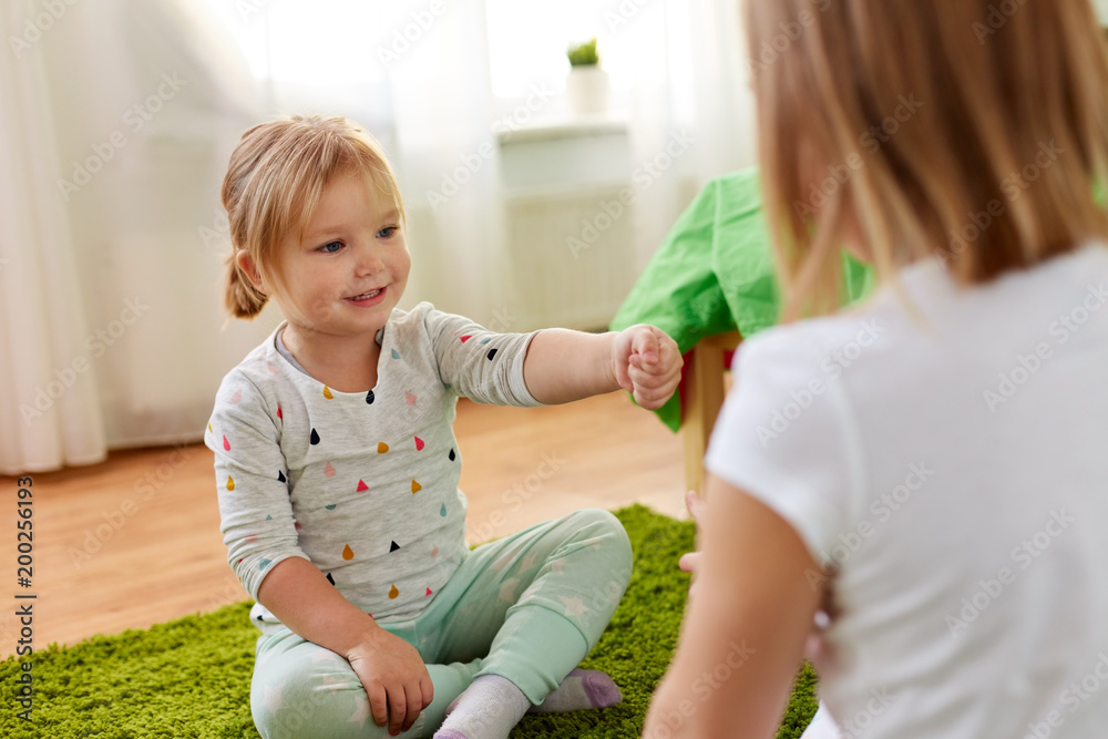 childhood, leisure and family concept - little girls playing rock-paper-scissors game at home childhood, leisure and family concept - little girls playing rock-paper-scissors game at home