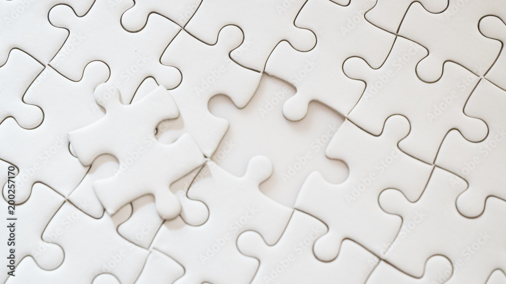hand holding piece of white jig saw puzzle place to match or completing the final pazzle piece.Success,game,solve problem business concept. hand holding piece of white jig saw puzzle place to match or completing the final pazzle piece.Success,game,solve problem business concept.