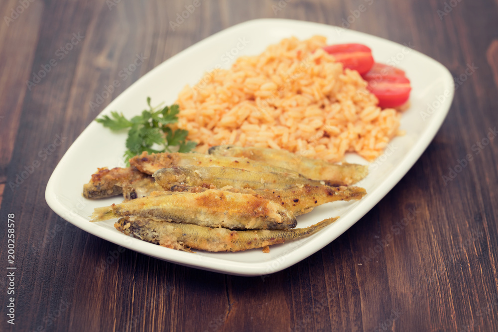 fried smelts with tomato rice on white dish fried smelts with tomato rice on white dish