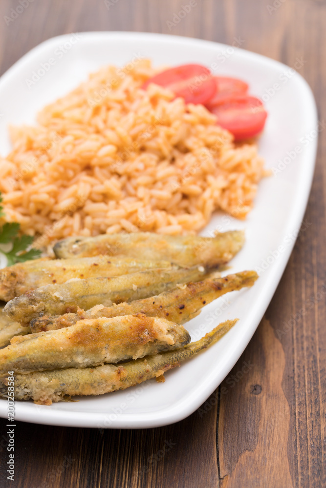 fried smelts with tomato rice on white dish fried smelts with tomato rice on white dish