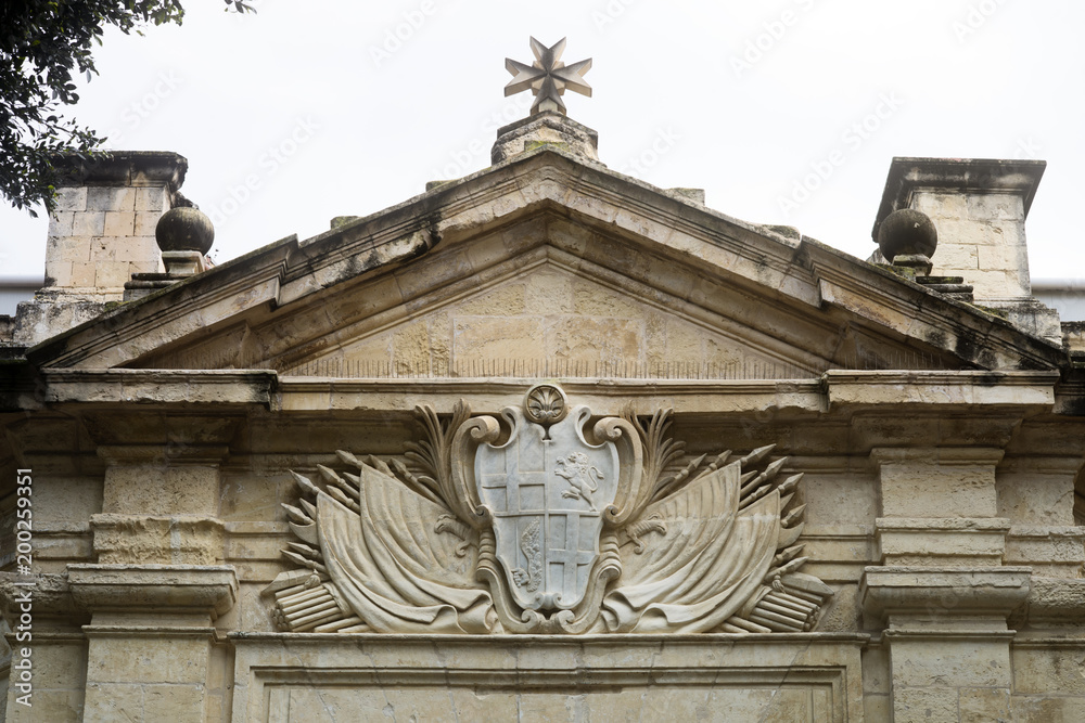 Stone Carved Coat Of Arms And Maltese Cross Above The Entrance Of The Knights Hospitallers Church, Valletta, Malta