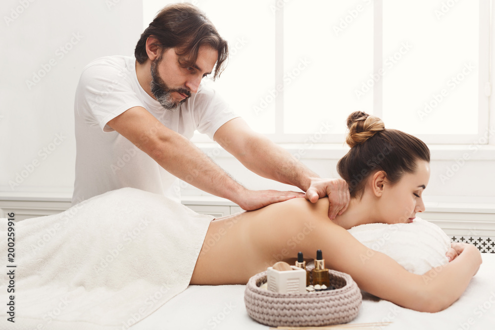 Male masseur doing professional body massage - obrazy, fototapety, plakaty 