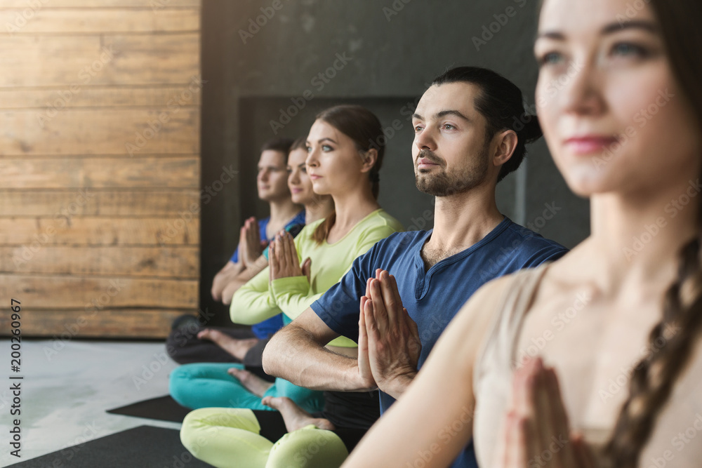 Young women and men in yoga class, relax meditation pose Young women and men in yoga class, relax meditation pose