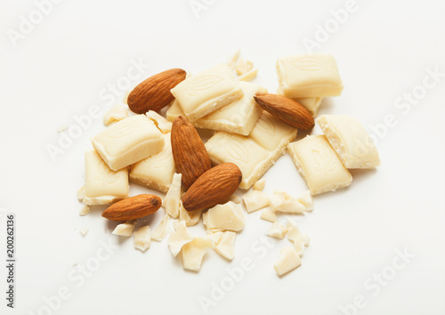 Broken white chocolate bar and almonds isolated