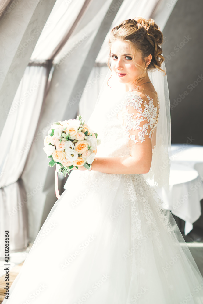 Naklejka premium Portrait of stunning bride with long hair posing with great bouquet