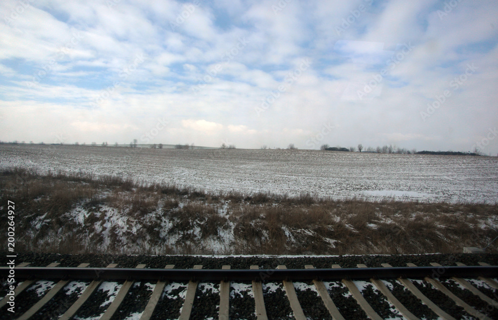beautiful winter landscape with blue cloudy sky, frosty fields and trees in the background, with railroad trucks on a sunny day in Poland, Europe beautiful winter landscape with blue cloudy sky, frosty fields and trees in the background, with railroad trucks on a sunny day in Poland, Europe