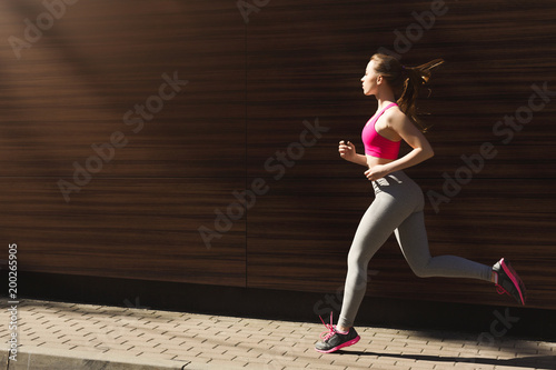 Young woman jogging in city copy space