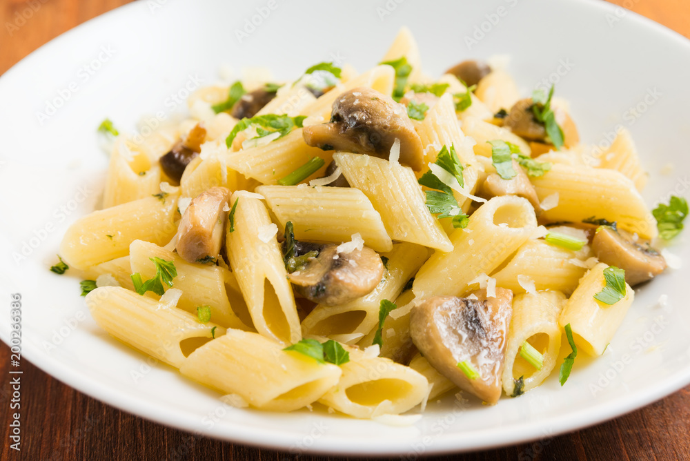 Piatto di penne ai funghi, prezzemolo e formaggio 