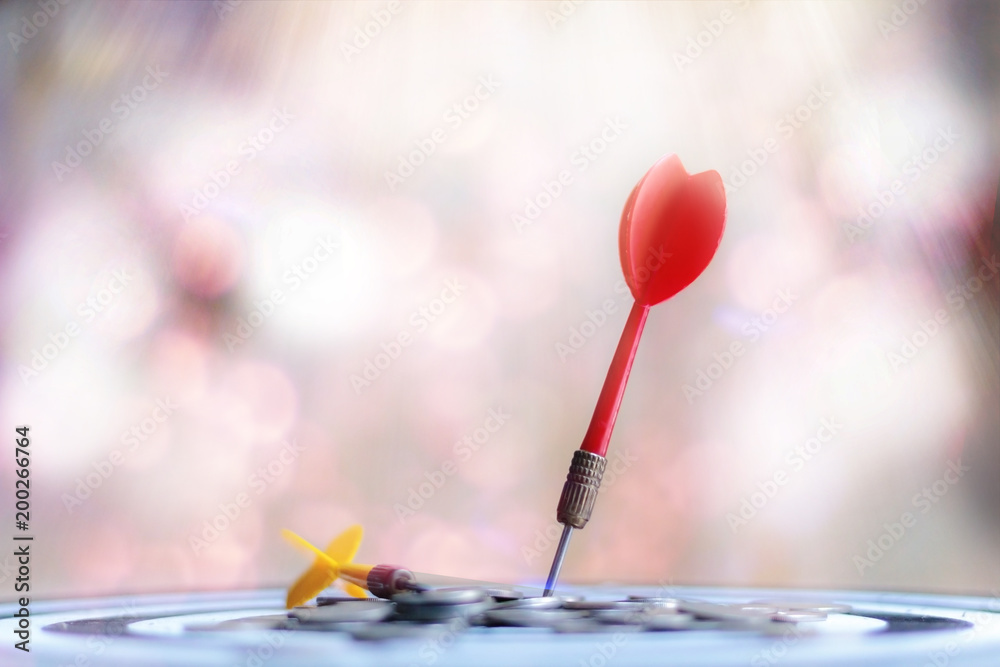 Red dart arrow hit the center target of dartboard and money coin metaphor marketing or saving money concept Red dart arrow hit the center target of dartboard and money coin metaphor marketing or saving money concept