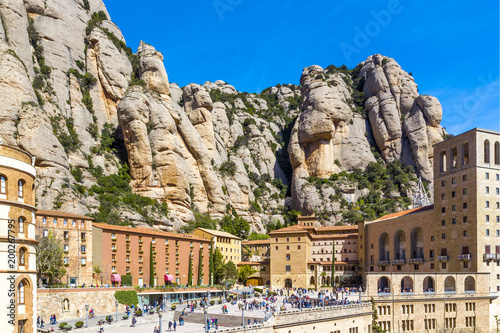 Top view of Santa Maria de Montserrat Abbey in Monistrol de Montserrat (Montserrat Monastery) and big, high rocky mountains on sunny day, Catalonia, Spain