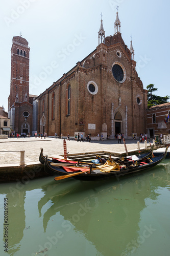 Channel with gondolas, Basilica of Santa Maria Gloriosa dei Frari on background photo