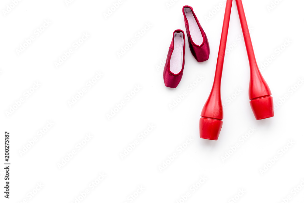 Beauty sport for girls concept. Maces for rhythmic gymnastics and ballet shoes on white background top view copy space Beauty sport for girls concept. Maces for rhythmic gymnastics and ballet shoes on white background top view copy space