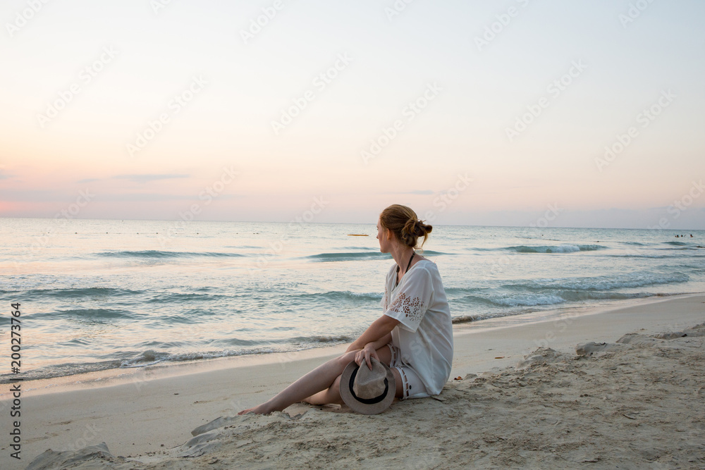 Eine junge Frau spaziert am Strand in der Karibik