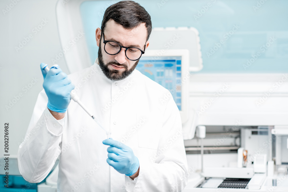 Laboratory assistant working with test tube near the medical analizer machine at the laboratory Laboratory assistant working with test tube near the medical analizer machine at the laboratory