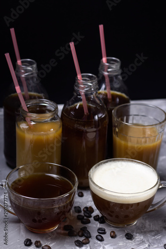 various of  coffee drinks in different cups and bottles dark background