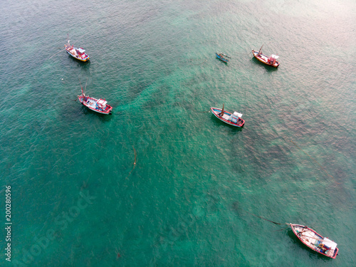 A lot of bright and colorful fishing boats in the ocean.