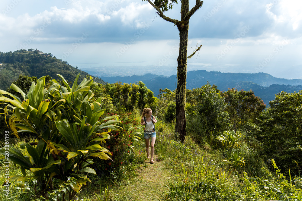 Fototapeta premium Junge Frau wandert in den Bergen in der Karibik auf Jamaika