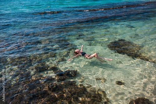 Eine junge Frau schwimmt  in der Karibik auf der Jamaika
