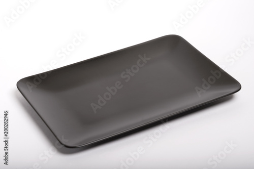 Empty black plate on an isolated white background. View from above.