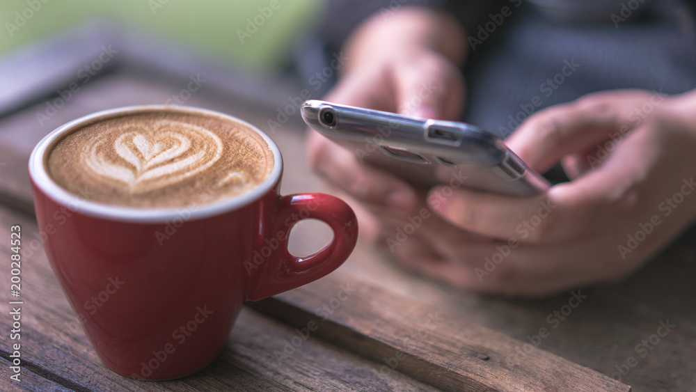 Fototapeta Mockup image of mobile phone and hot latte coffee