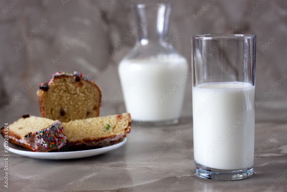 Delicious aromatic cake and a glass of milk on a table with a marbled background. Delicious aromatic cake and a glass of milk on a table with a marbled background.