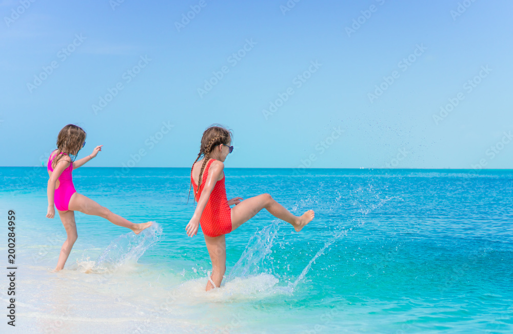 Little happy girls splashing. Kids running to the turquoise water ready to swim