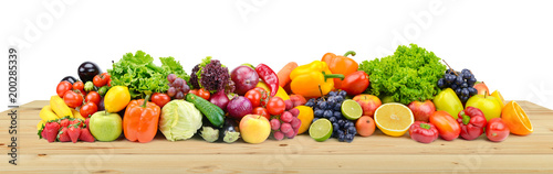 Vegetables and fruits on wooden table boards isolated on white