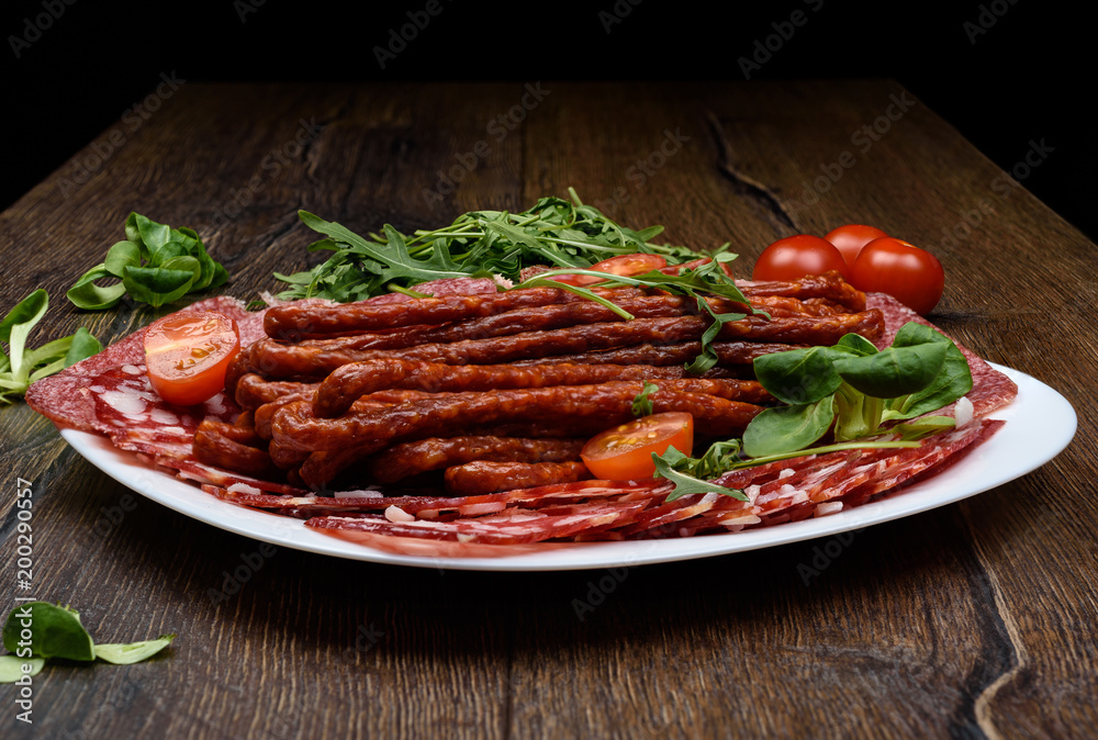 A plate with different types of sausage on a wooden table