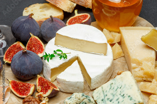 Brie cheese on a wooden Board with fresh figs and honey