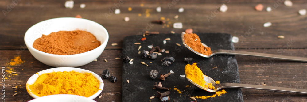 Spices and herbs. Variety of spices and herbs on a dark wooden surface Spices and herbs. Variety of spices and herbs on a dark wooden surface