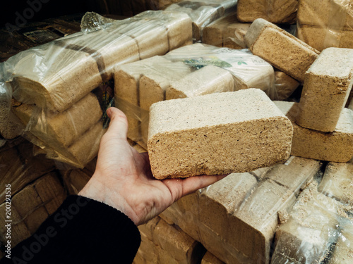 Alternative fuel, eco fuel, bio fuel. Wood sawdust briquettes for stoves. Lean-burn with good heat output. Briquettes from sawdust on a green background.