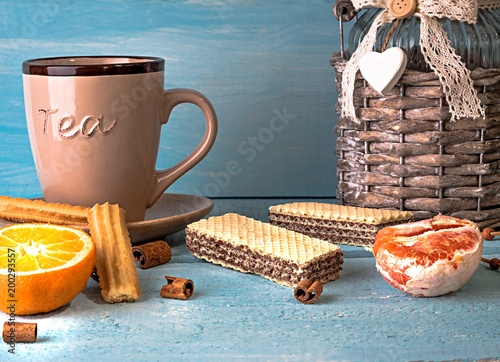 morning scene with cup of tea or coffee, Dutch cookie stroopwafel, Delfts blue souvenir, on blue table