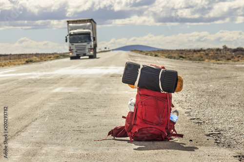 Red backpack in the road with truck in the background photo