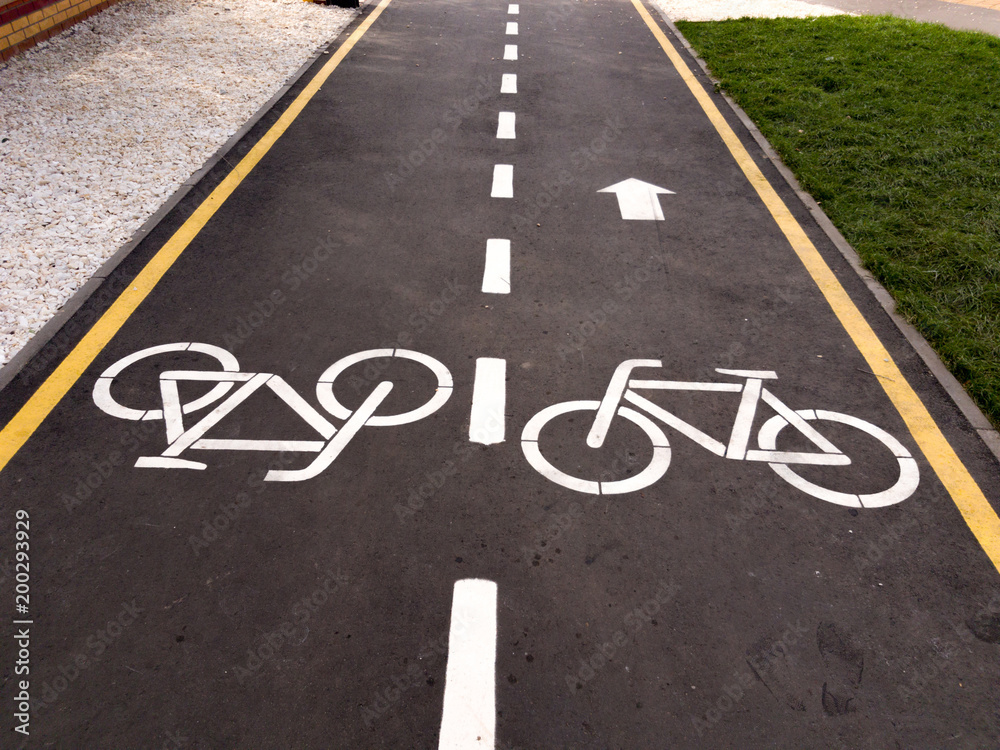 White bicycle sign with arrow on the asphalt, bike road sign on the street, bicycle lane sign on street, gray background