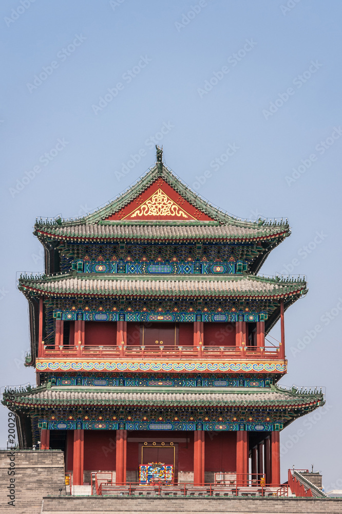 Fototapeta premium Beijing, China - April 27, 2010: Upper Structure in pagoda-style traditional architecture of Qianmen, Southern Gate, at edge of Tiananmen Square against blue sky. Reds, blues and gold.