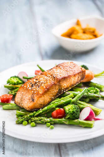 Photography Roasted salmon steak with asparagos broccoli carrot tomatoes radish green beans and peas
