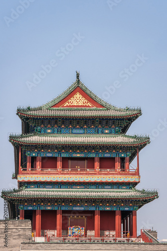 Beijing, China - April 27, 2010: Upper Structure in pagoda-style traditional architecture of Qianmen, Southern Gate, at edge of Tiananmen Square against blue sky. Reds, blues and gold.