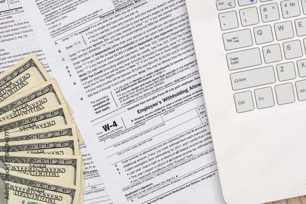 W-4 form with money and personal computer W-4 form with money and personal computer
