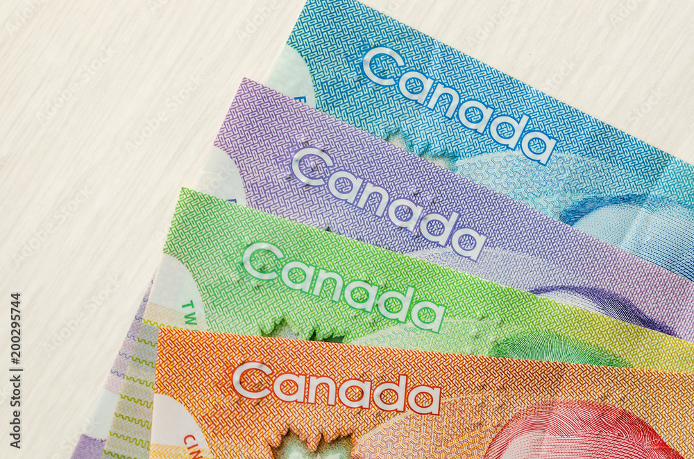 Obraz premium Colourful canadian dollar banknotes on wooden background