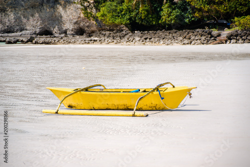 Small yellow bangka boat on the sandy beach, Philippines