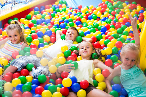 kids playing with multicolored plastic balls .