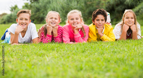 Portrait of five kids who are walking and posing lying