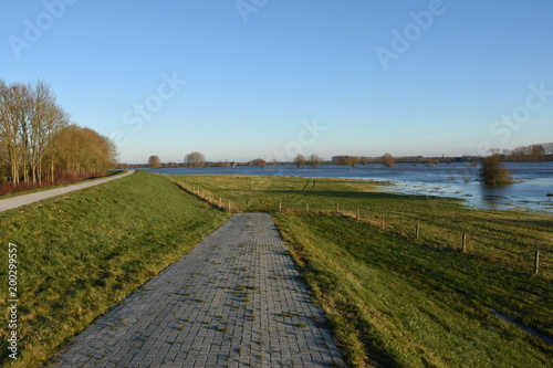 een toegangsweg naar weiland bij overstroomde IJssel
