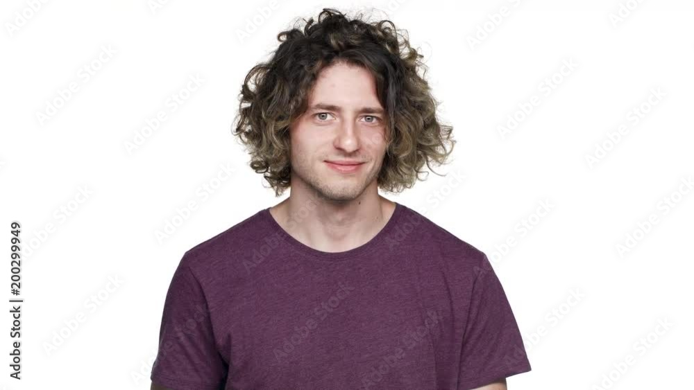 Portrait of good-looking hairy man in casual t-shirt smiling and gesturing finger on you with winking, isolated over white background. Concept of emotions