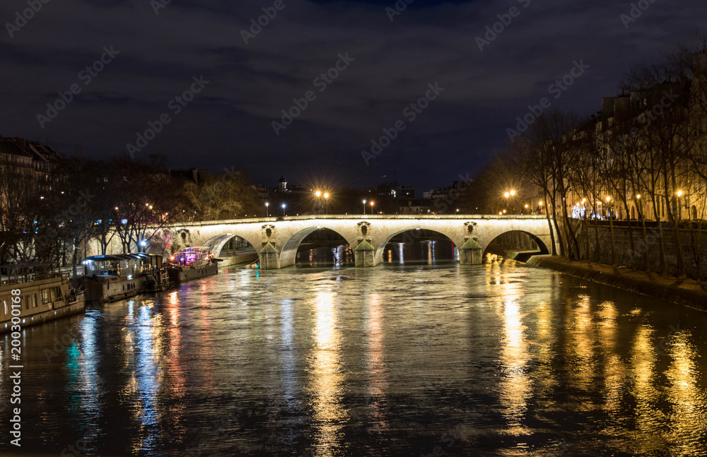  the bridge over the Seine was seen at night, beautifully illuminated