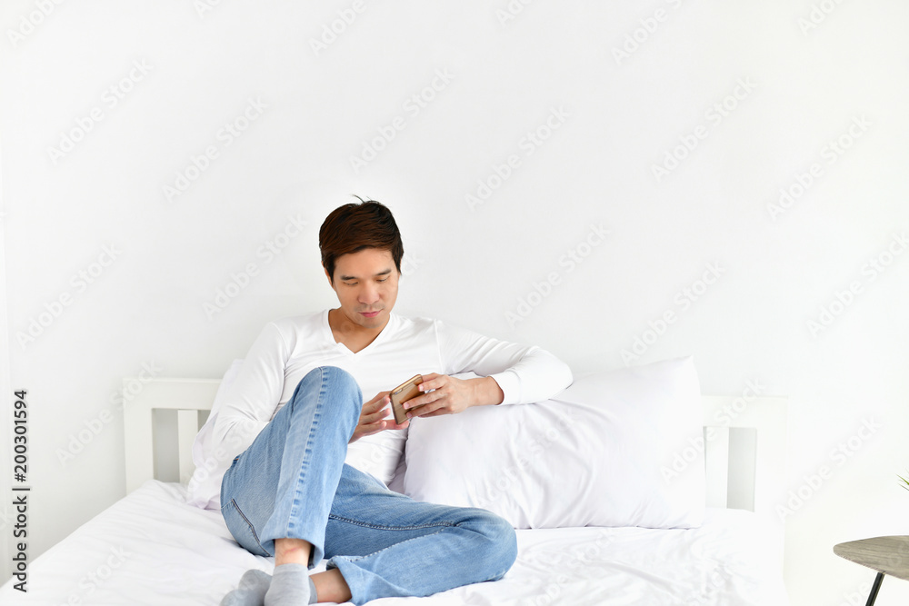 Men are playing mobile in the bedroom.
