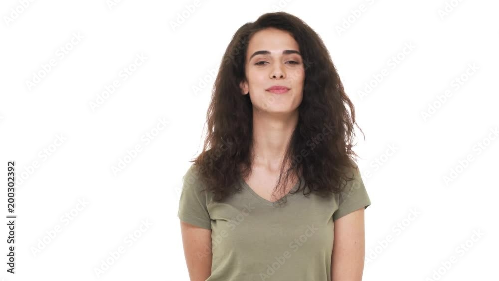Closeup portrait of charming lady having curly hairstyle looking on camera flirty and smiling happily with perfect teeth, over white background in studio. Concept of emotions Closeup portrait of charming lady having curly hairstyle looking on camera flirty and smiling happily with perfect teeth, over white background in studio. Concept of emotions