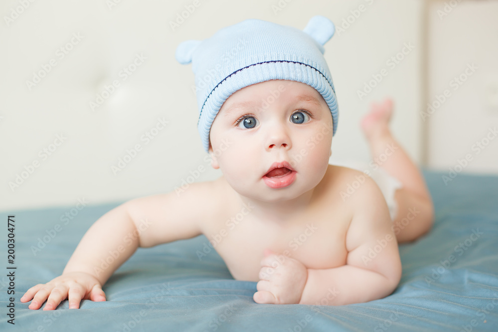Little funny baby boy with big blue eyes smiling with cute cap with ears on his head Little funny baby boy with big blue eyes smiling with cute cap with ears on his head