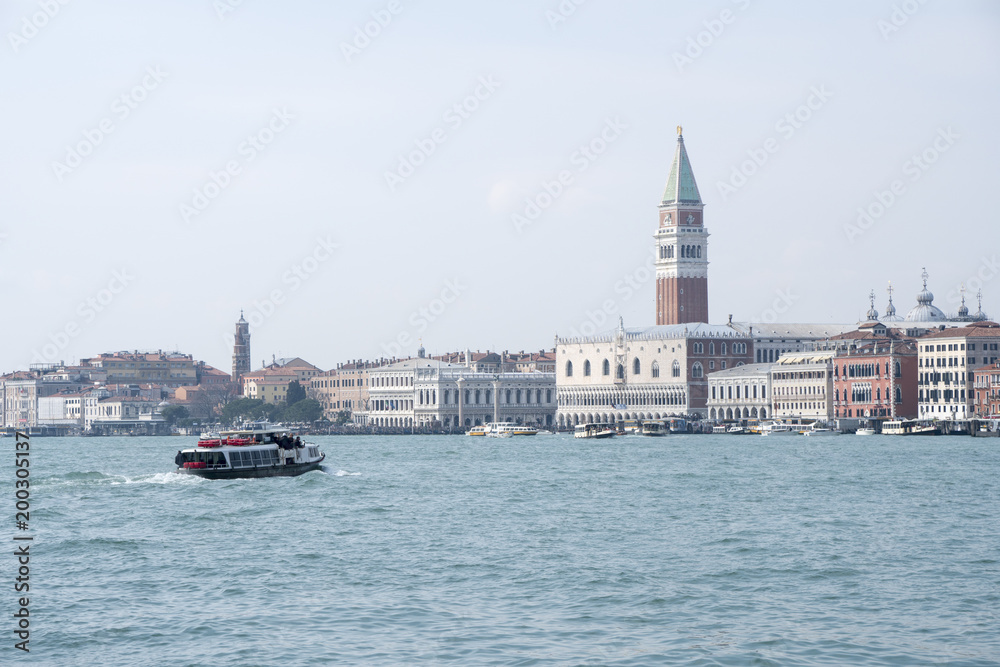 Fototapeta premium Venice, Italy: a public transport boat, called vaporetto, goes towards Palazzo Ducale and Piazza San Marco